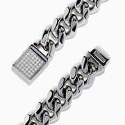 The Men's Sterling Silver Diamond Cuban Link Bracelet features a thick Cuban link chain and a rectangular clasp set with small diamonds, displayed in a circular shape on a white background.