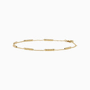 The 14K Yellow Gold Beaded Station Anklet features a delicate fine chain with evenly spaced bead clusters and a secure lobster clasp.