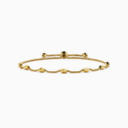 The 14K Yellow Gold Wheat Bolo Chain Bracelet features a twisted rope design with evenly spaced textured gold beads and an adjustable sliding clasp with decorative end pieces.