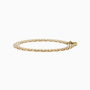 A thick, 14 karat yellow gold hollow snake skin bracelet with a round clasp, displayed in a circular shape on a white background.