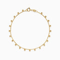 The 14K Yellow Gold Tassel Bead Chain Bracelet features small, evenly spaced round charms on a delicate chain, finished with a secure lobster clasp closure.