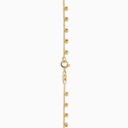 The 14K Yellow Gold Tassel Bead Chain Bracelet features small, evenly spaced round charms on a delicate chain, finished with a secure lobster clasp closure.