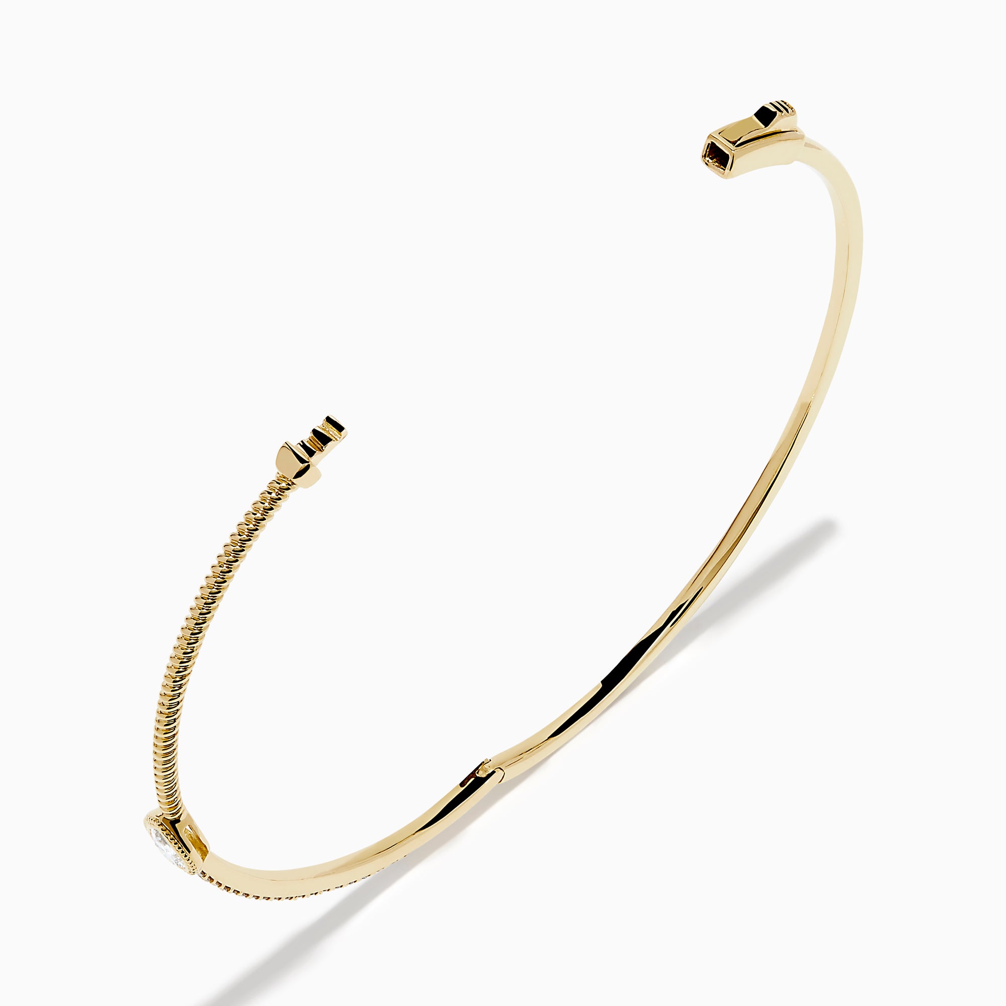 The D'Oro 14K Yellow Gold Pear Bezel Diamond Bangle showcases a row of small diamonds and a central pear bezel-set gem, all elegantly displayed against a plain white background.