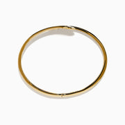 The D'Oro 14k Yellow Gold Diamond Bypass Bangle showcases two overlapping ends tipped with pear-shaped diamonds and a band lined with small round diamonds.