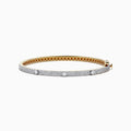 The DOro 14K Yellow Gold Diamond Bangle showcases a honeycomb interior and three large round diamonds set among smaller diamonds on its exterior.