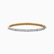 The DOro 14K Yellow Gold Diamond Bangle showcases a honeycomb interior and three large round diamonds set among smaller diamonds on its exterior.