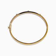 The DOro 14K Yellow Gold Diamond Bangle showcases a honeycomb interior and three large round diamonds set among smaller diamonds on its exterior.