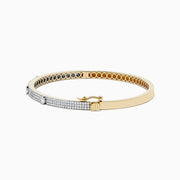 The DOro 14K Yellow Gold Diamond Bangle showcases a honeycomb interior and three large round diamonds set among smaller diamonds on its exterior.
