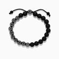 The Mens Beaded Hematite String Bracelet features alternating matte black and faceted dark gray beads on a black adjustable cord with knotted ends—an elegant accessory for any occasion.