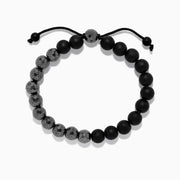 The Mens Beaded Hematite String Bracelet features alternating matte black and faceted dark gray beads on a black adjustable cord with knotted ends—an elegant accessory for any occasion.