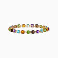 The 14K Yellow Gold Cushion Cut Multi Color Gemstone Tennis Bracelet showcases a row of cushion-cut multicolored gemstones set in yellow gold, displayed against a white background.