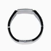 The Mens 925 Sterling Silver Black Sapphire Leather Bracelet features black braided leather, a silver clasp, and a rectangular sterling silver accent set with black stones. The design resembles a stylish black sapphire bracelet against a plain white background.
