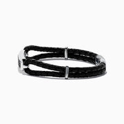 The Mens 925 Sterling Silver Black Sapphire Leather Bracelet features black braided leather, a silver clasp, and a rectangular sterling silver accent set with black stones. The design resembles a stylish black sapphire bracelet against a plain white background.