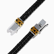 Mens 925 Sterling Silver and Leather Onyx Bracelet features black braided leather, gold and sterling silver accent clasps, a black rectangular plate, and a small round emblem on a white background.