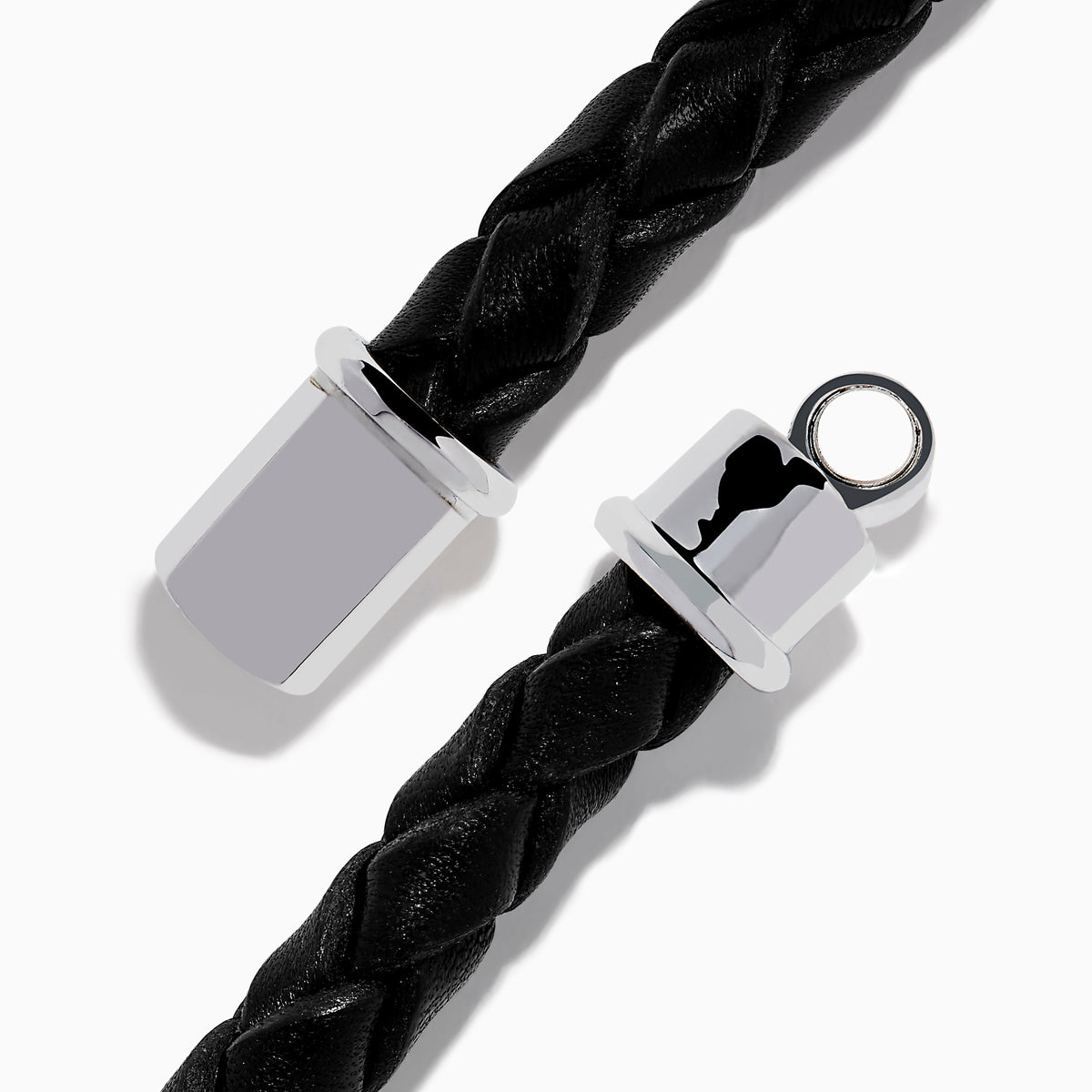 The Mens 925 Sterling Silver Spinel Leather Bracelet features black braided leather, a shiny sterling silver clasp, and a rectangular silver accent with sparkling black spinels, displayed against a white background.