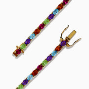 The 925 Sterling Silver 18K Plated Multi Gemstone Bracelet showcases alternating oval-cut blue, green, orange, and red gemstones in a continuous pattern, secured with a clasp.
