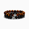 The Tiger's Eye and Onyx Beaded 2-Piece Bracelet Set with Sterling Silver features brown and black beads, each bracelet accented by a single sterling silver bead with a textured, woven pattern for an elegant stacked look.