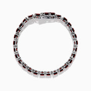 The 925 Sterling Silver Garnet Bracelet features round, deep red garnets set in individual prongs along a sleek tennis chain, beautifully arranged in a circular shape on a white background.