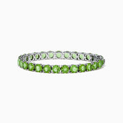 The 925 Sterling Silver Peridot Bracelet showcases a row of oval, bright green gemstones set against a white background for a striking look.