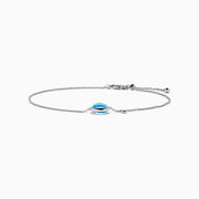 The Ocean Bleu 14K White Gold Blue Topaz and Diamond Bolo Bracelet features a delicate chain, a central round blue topaz, sparkling diamonds, and an adjustable clasp with a small charm near the closure.
