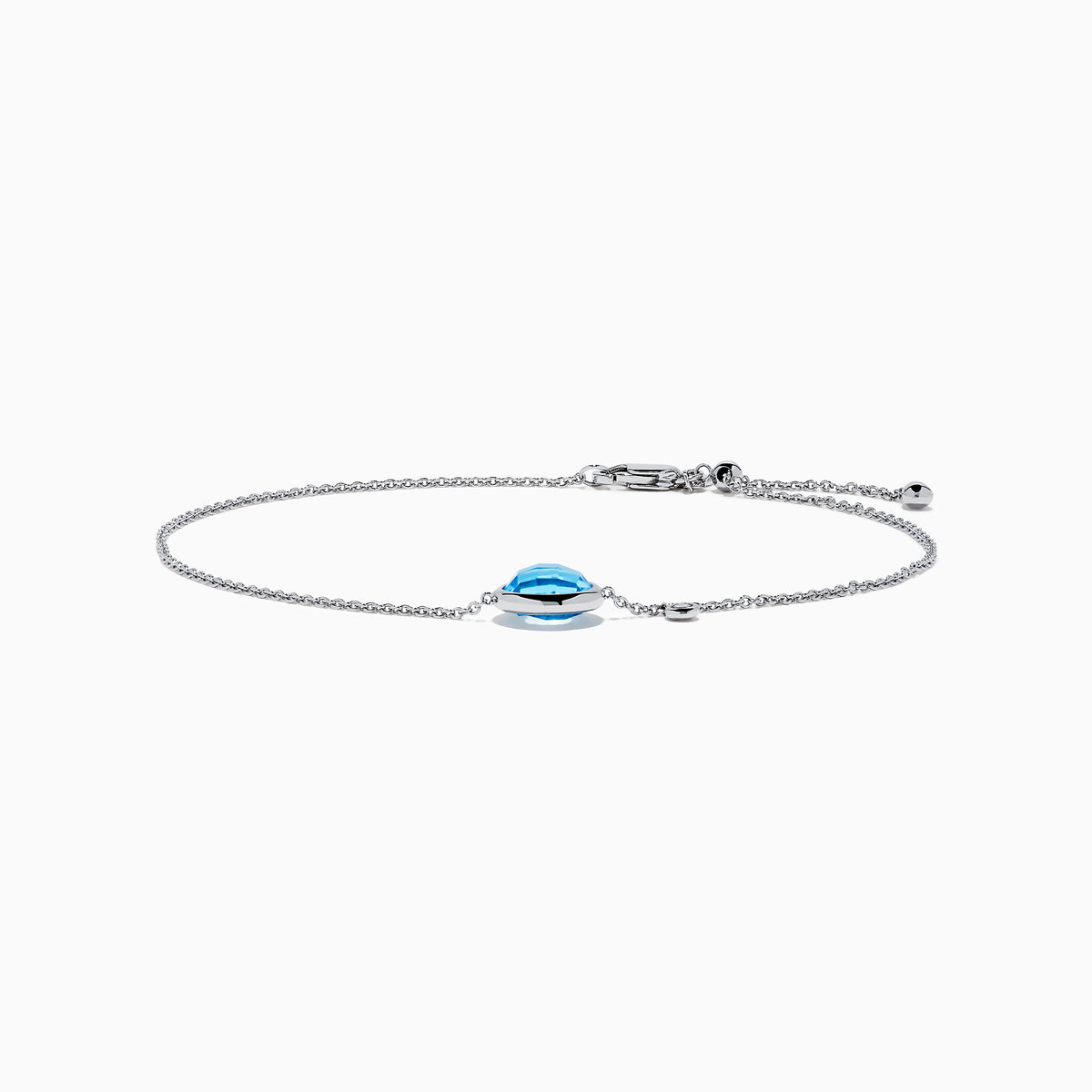 The Ocean Bleu 14K White Gold Blue Topaz and Diamond Bolo Bracelet features a delicate chain, a central round blue topaz, sparkling diamonds, and an adjustable clasp with a small charm near the closure.