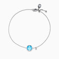The Ocean Bleu 14K White Gold Blue Topaz and Diamond Bolo Bracelet features a delicate chain, a central round blue topaz, sparkling diamonds, and an adjustable clasp with a small charm near the closure.