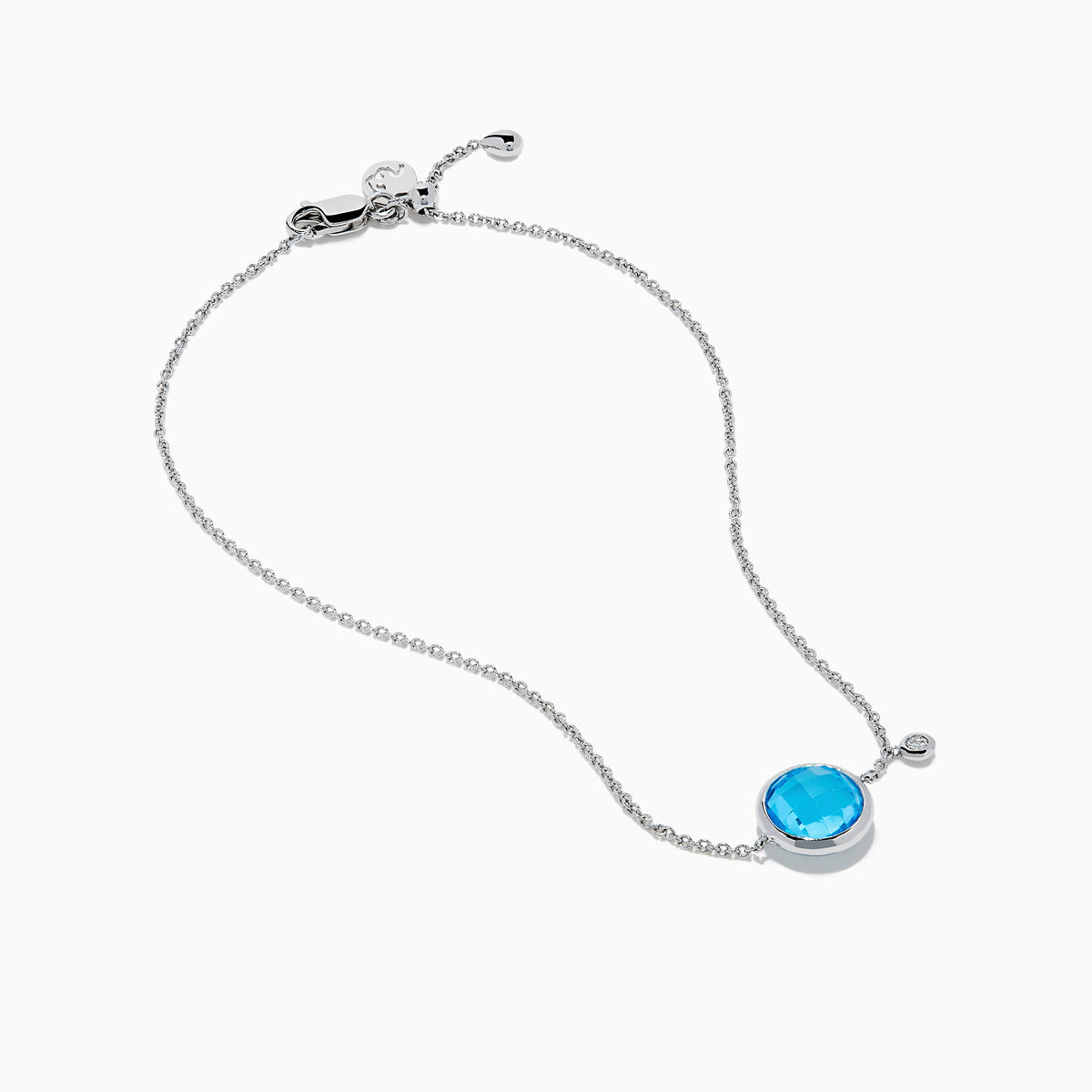 The Ocean Bleu 14K White Gold Blue Topaz and Diamond Bolo Bracelet features a delicate chain, a central round blue topaz, sparkling diamonds, and an adjustable clasp with a small charm near the closure.
