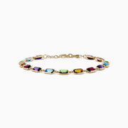 The Mosaic 14K Yellow Gold Bezel Multi Color Gemstone Bracelet showcases blue, green, purple, red, and amber rectangular stones evenly spaced along a delicate chain with an adjustable clasp.