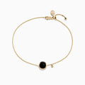 The 14K Yellow Gold Onyx and Diamond Bolo Bracelet features a delicate gold chain with a round onyx in a bezel setting, an accent diamond charm, and is finished with a bolo clasp and heart-shaped tag.