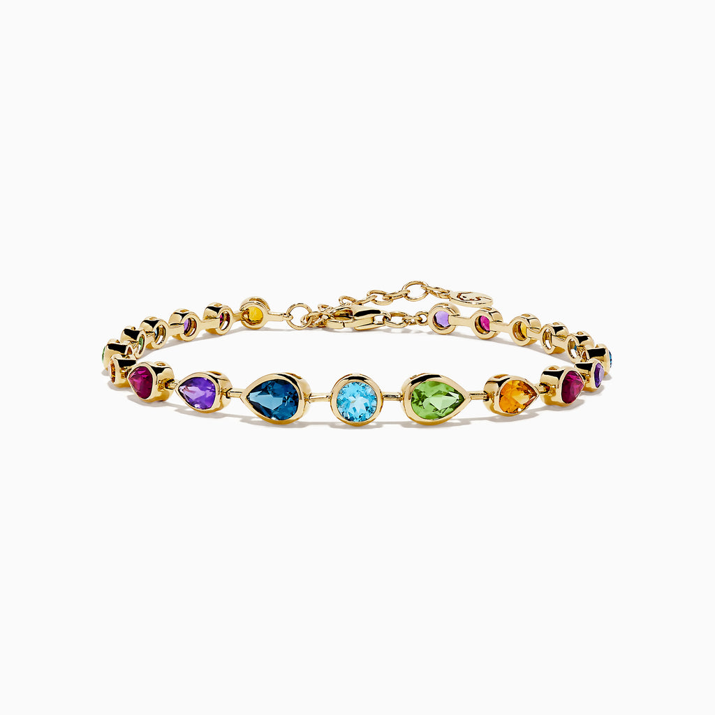 The Mosaic 14K Yellow Gold Bezel Set Multi Gemstone Adjustable Tennis Bracelet (7.0 TCW) features faceted oval gemstones in purple, blue, green, and orange hues with an adjustable clasp, shown on a white background.