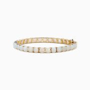The Aurora 14K Yellow Gold Opal Tennis Bracelet 17.40 TCW showcases oval opals set in prongs on 14K yellow gold, displayed against a white background.