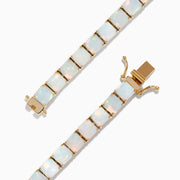 The Aurora 14K Yellow Gold Opal Tennis Bracelet 17.40 TCW showcases oval opals set in prongs on 14K yellow gold, displayed against a white background.
