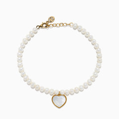 The 14K Gold Fresh Water Pearl and Mother of Pearl Heart Charm Bracelet features a gold clasp and extender, with a heart charm outlined in gold and filled with iridescent mother of pearl, shown against a white background.