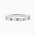 The 925 Sterling Silver Multi Gemstone and Diamond Bangle features small, round gemstones in vibrant red, purple, green, blue, and orange hues set evenly along a sleek silver band.