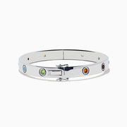The 925 Sterling Silver Multi Gemstone and Diamond Bangle features small, round gemstones in vibrant red, purple, green, blue, and orange hues set evenly along a sleek silver band.