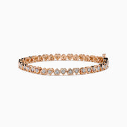 A Rose Plated Sterling Silver Diamond Hearts Tennis Bracelet, featuring alternating heart-shaped links with sparkling diamonds, is displayed against a white background.