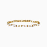 The Lab Grown Emerald Cut Diamond 7.50ct Tennis Bracelet in 14K Yellow Gold features a single row of rectangular lab-grown diamonds, elegantly set and displayed on a plain white background.
