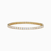 The Lab Grown Round Diamond 7.00ct Tennis Bracelet in 14K Yellow Gold showcases a single row of sparkling lab-grown diamonds set in a continuous line of yellow gold, displayed against a white background.