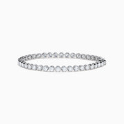 The Lab Grown Round Diamond 5.00ct Cupcake Setting Tennis Bracelet in 14K White Gold features a slender band adorned with a continuous row of sparkling lab grown diamonds.