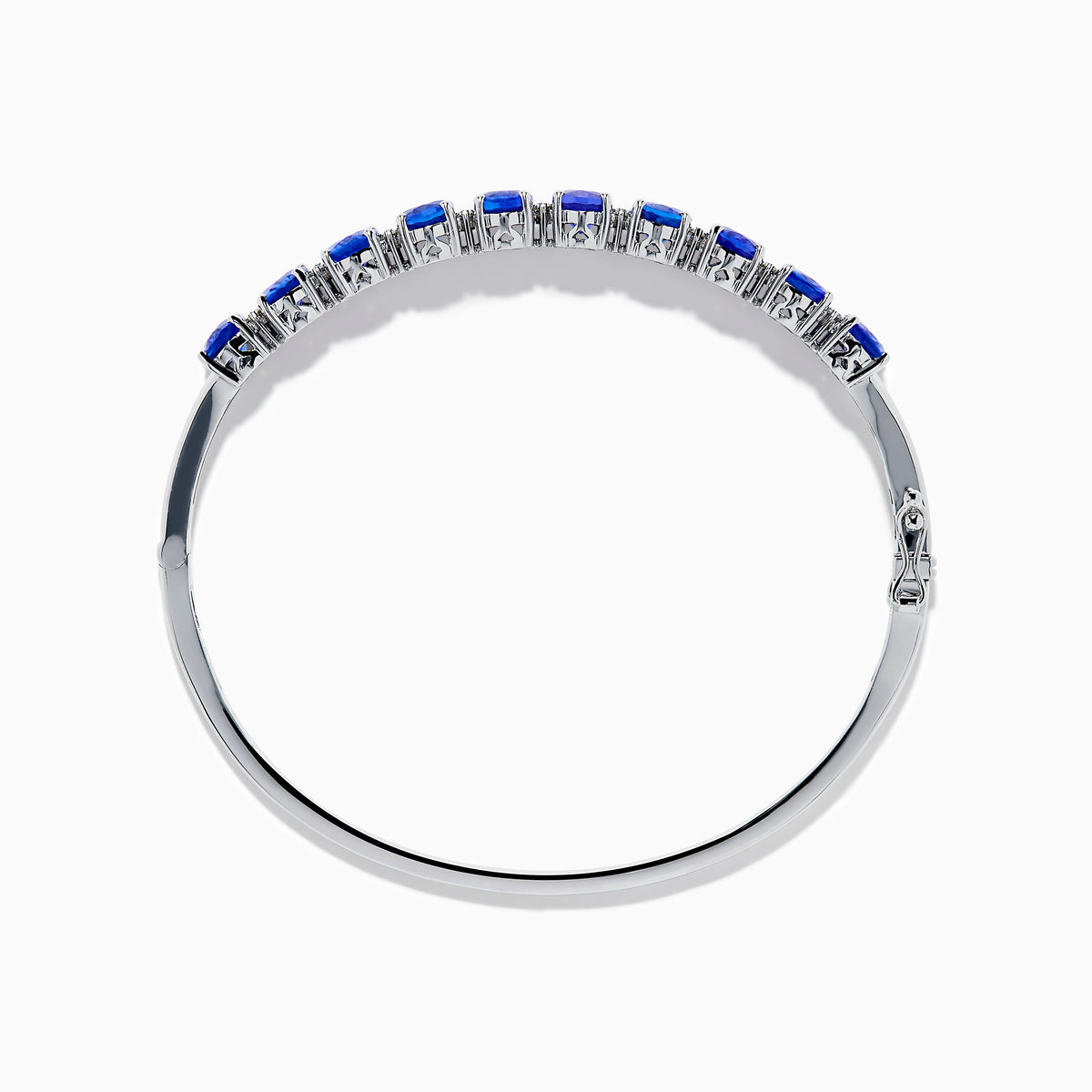 The 14K White Gold Tanzanite and Diamond Bangle features a row of oval-shaped blue tanzanites set in the center, displayed against a white background.