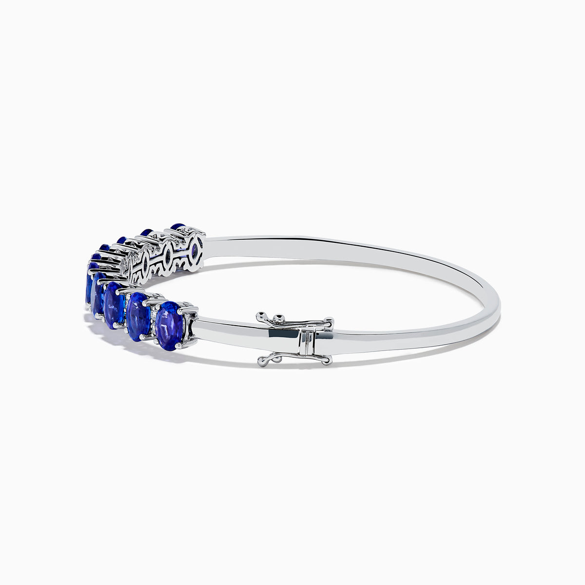 The 14K White Gold Tanzanite and Diamond Bangle features a row of oval-shaped blue tanzanites set in the center, displayed against a white background.