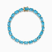 The Ocean Bleu 14K Yellow Gold Radiant Cut Blue Topaz Tennis Bracelet features rectangular blue topaz gemstones set in individual links, displayed on a plain white background.