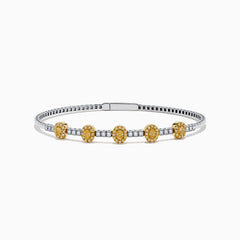 The Canare Platinum and 18K Yellow Gold Yellow and White Diamond Bangle features five oval yellow gold accents, each set with yellow diamonds, spaced along clear square-cut white diamonds for a sleek, elegant look.