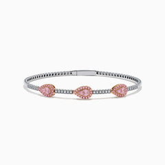 This Platinum and 14K Rose Gold Pink and White Diamond Bangle features three teardrop-shaped pink gemstone clusters framed by diamonds, creating an elegant look with evenly spaced gems along its slender silver-toned band.