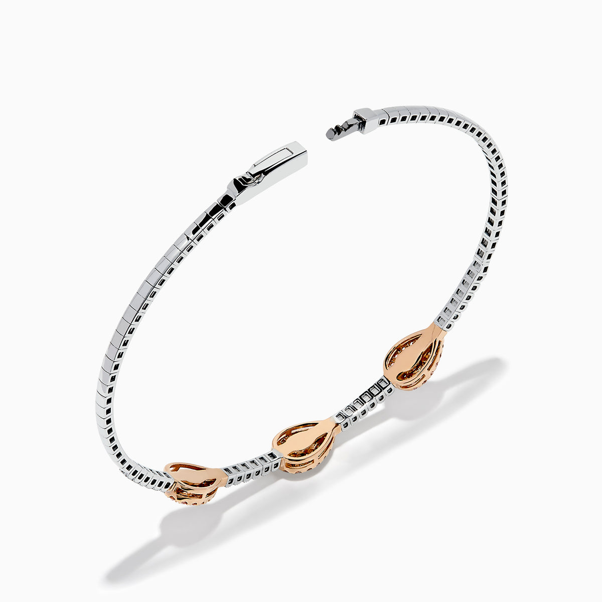 This Platinum and 14K Rose Gold Pink and White Diamond Bangle features three teardrop-shaped pink gemstone clusters framed by diamonds, creating an elegant look with evenly spaced gems along its slender silver-toned band.