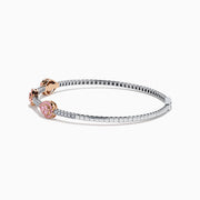 This Platinum and 14K Rose Gold Pink and White Diamond Bangle features three teardrop-shaped pink gemstone clusters framed by diamonds, creating an elegant look with evenly spaced gems along its slender silver-toned band.