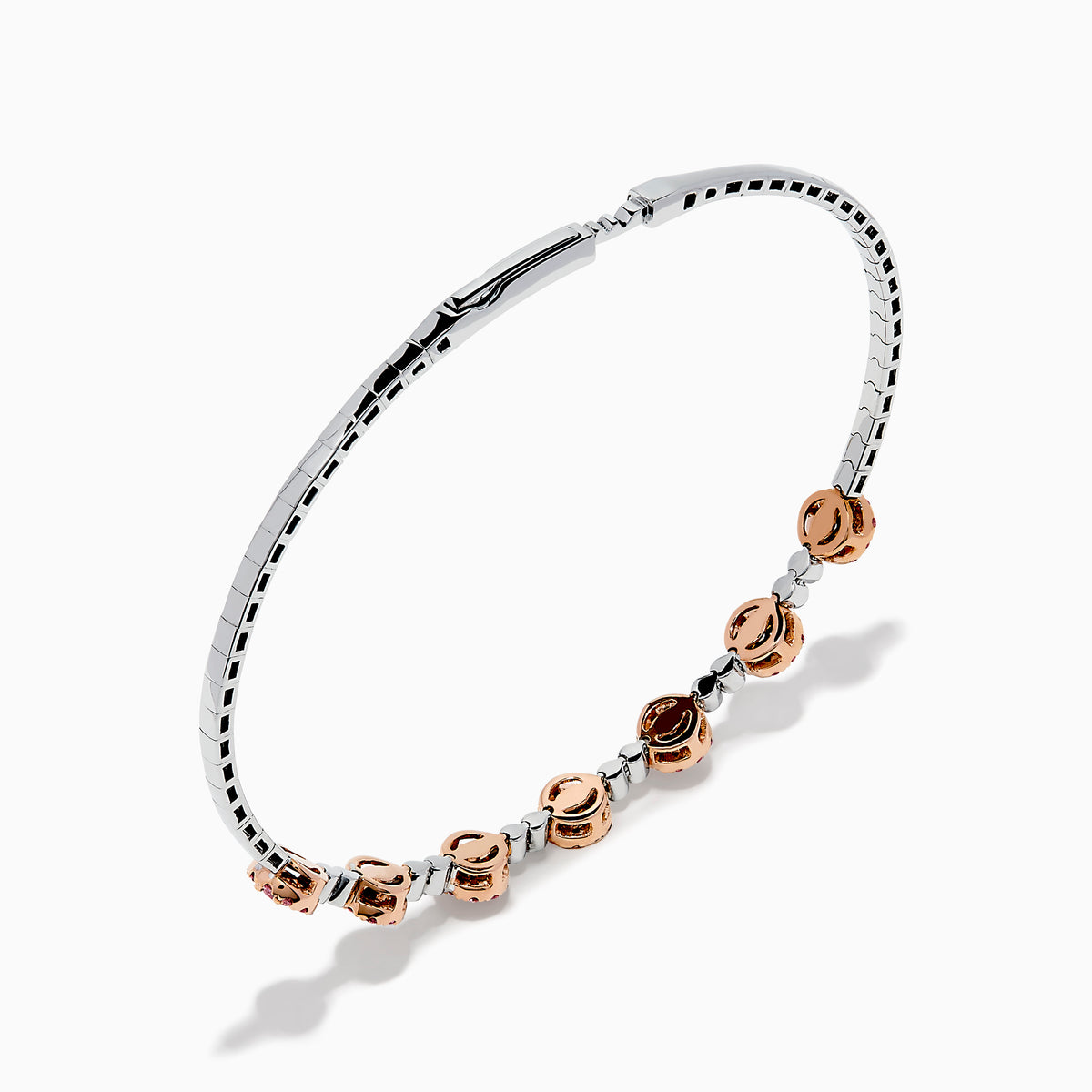The 14K White and Rose Gold Light Pink and White Diamond Bangle features a sleek silver band with seven clusters of light pink diamonds, each separated by a small white gemstone.