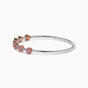 The 14K White and Rose Gold Light Pink and White Diamond Bangle features a sleek silver band with seven clusters of light pink diamonds, each separated by a small white gemstone.