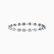 The Lab Grown Blue and White Diamond Multi Shape Tennis Bracelet in 14K White Gold showcases alternating oval, round, and emerald-cut lab-grown blue and white diamonds against a white background.