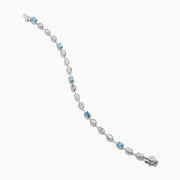 The Lab Grown Blue and White Diamond Multi Shape Tennis Bracelet in 14K White Gold showcases alternating oval, round, and emerald-cut lab-grown blue and white diamonds against a white background.